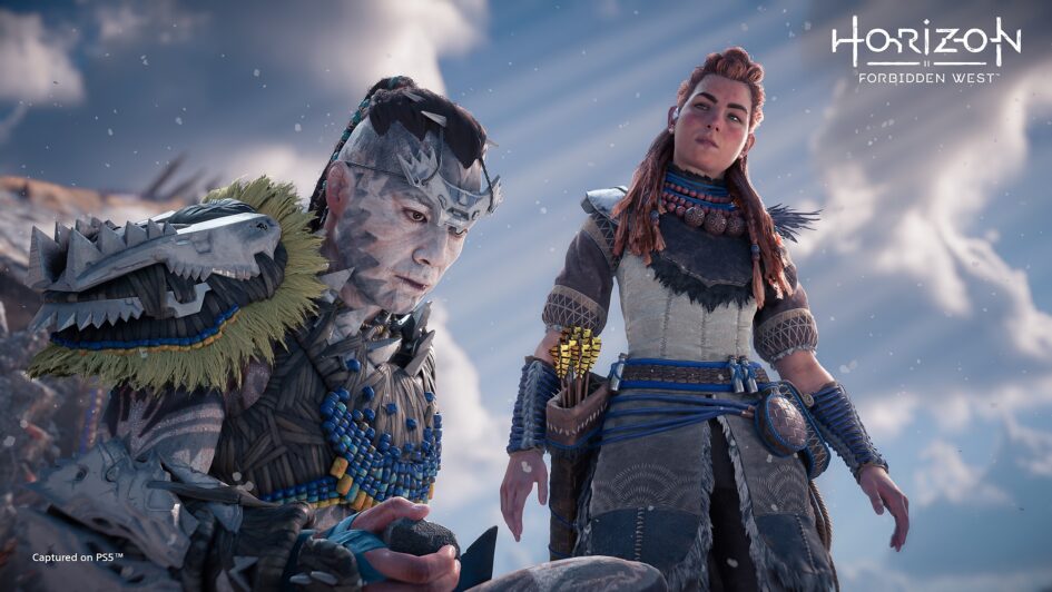 Image is displaying a man, Kotallo, crouching in front of a woman, Aloy.